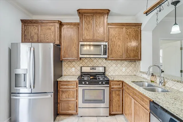 a kitchen with granite countertop a refrigerator stove and microwave