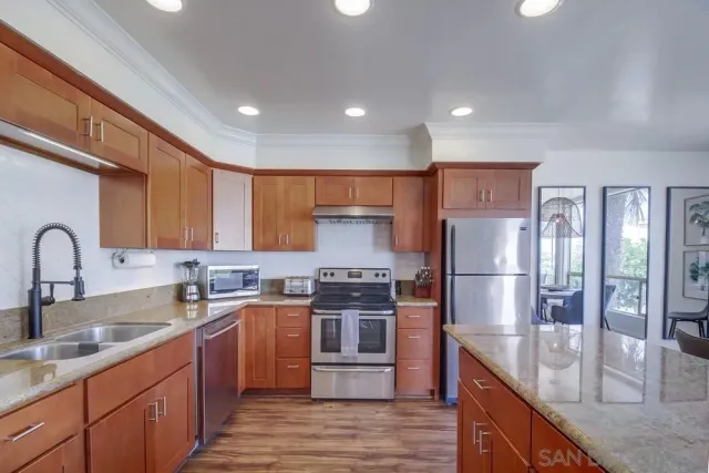 a kitchen with stainless steel appliances granite countertop a sink stove and refrigerator