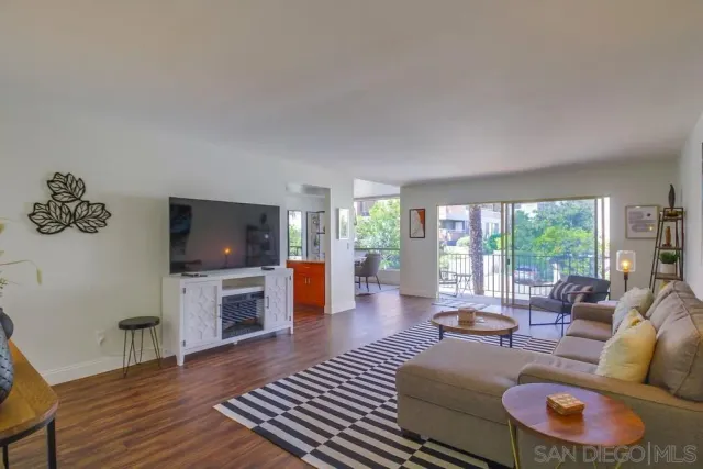 a living room with furniture a flat screen tv and a large window