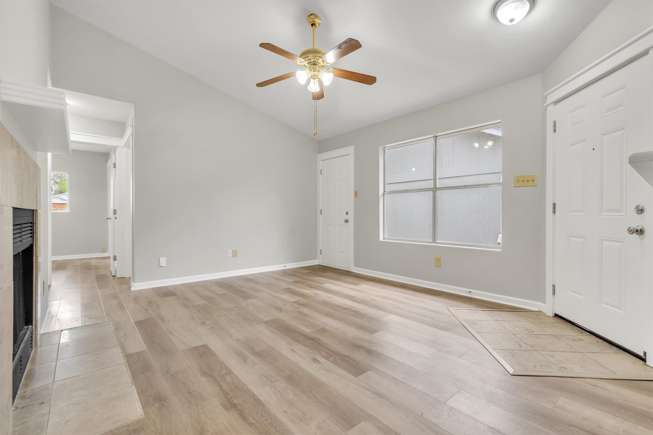 720 Decker Prairie Drive Austin, TX 78748 - Photo 5 of 21 Foyer featuring lofted ceiling, a fireplace, ceiling fan, and light wood finished floors