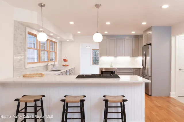 a kitchen with stainless steel appliances a sink a stove a refrigerator and cabinets