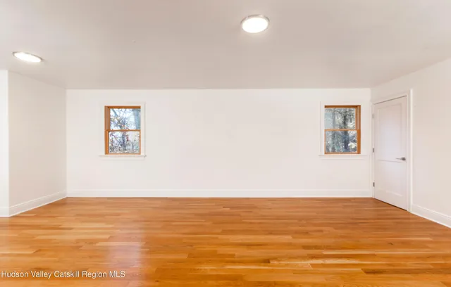 a view of empty room with wooden floor