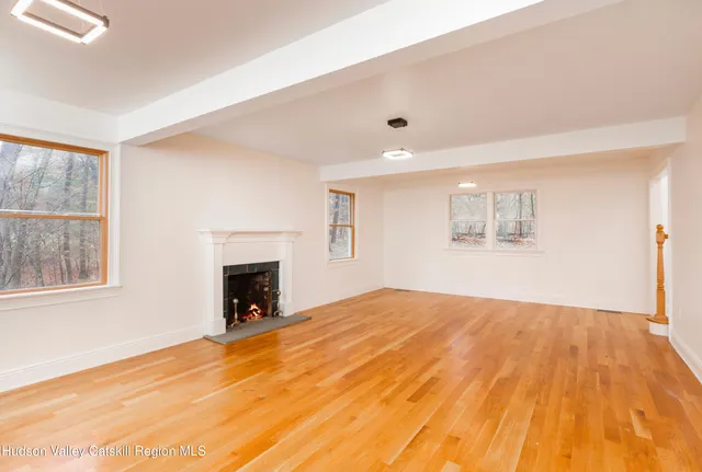 a view of empty room with wooden floor and fireplace