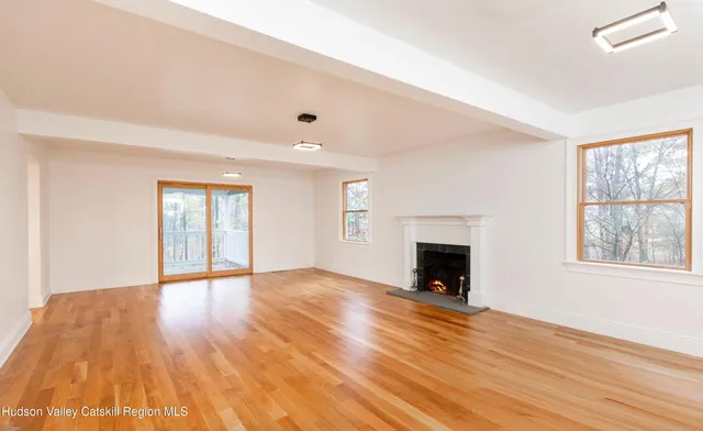 wooden floor fireplace and windows in an empty room