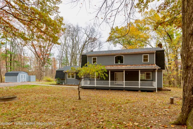 a view of a house with a yard and large tree