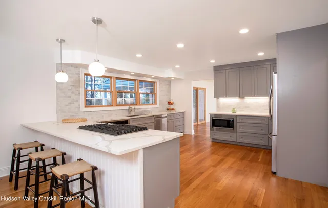 a kitchen with stainless steel appliances kitchen island granite countertop a stove a sink and a refrigerator