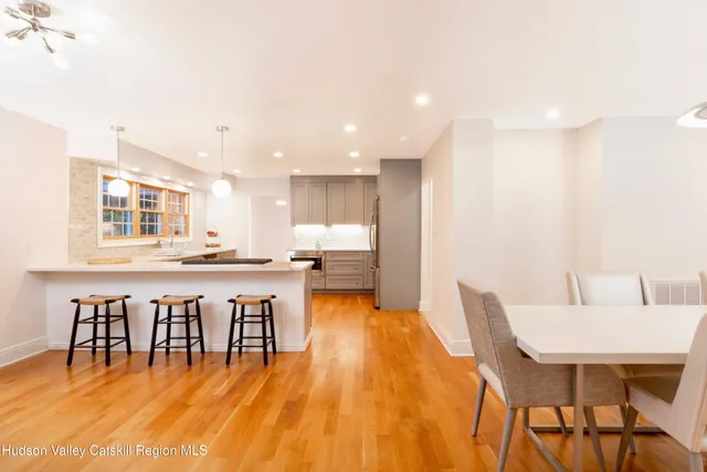 a living room with dining table and a large window