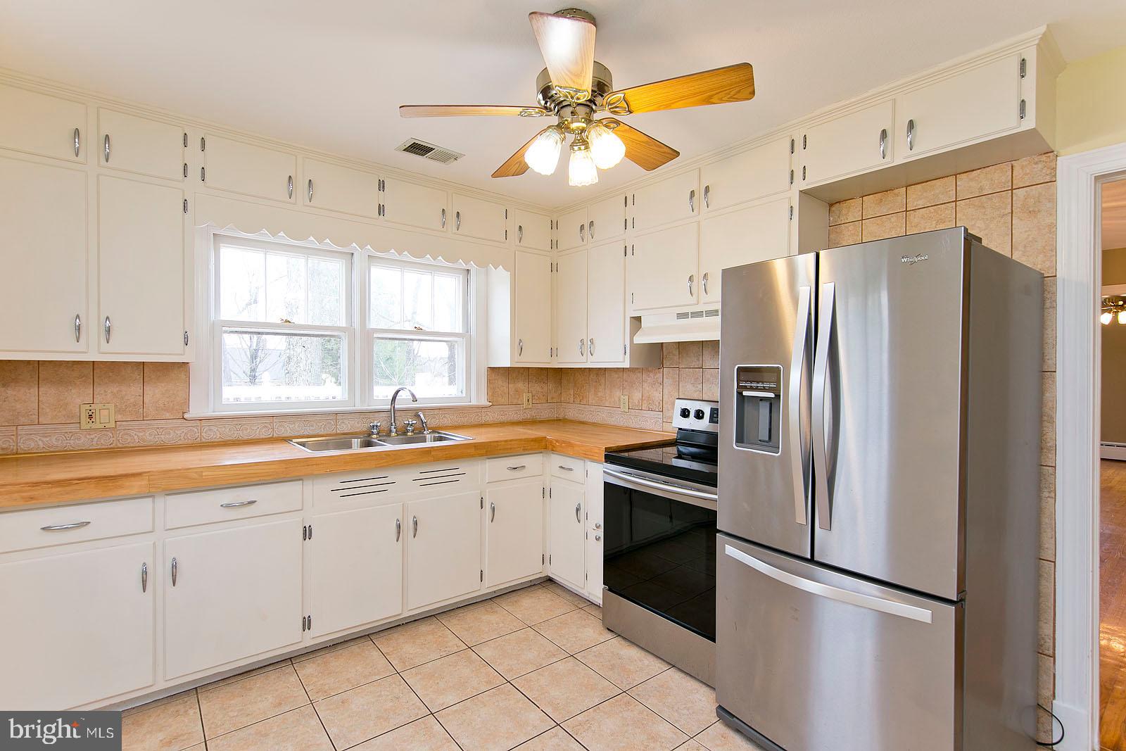 325 Berrys Ferry Road White Post, VA 22663 - Photo 12 of 60 a kitchen with white cabinets stainless steel appliances and a window