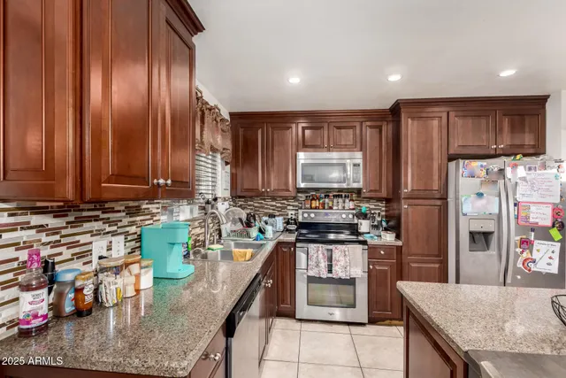 a kitchen with stainless steel appliances granite countertop a stove sink and cabinets