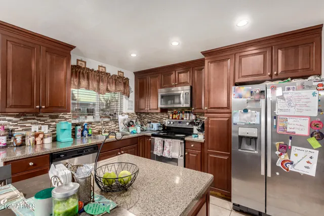 a kitchen with stainless steel appliances granite countertop a refrigerator sink and cabinets