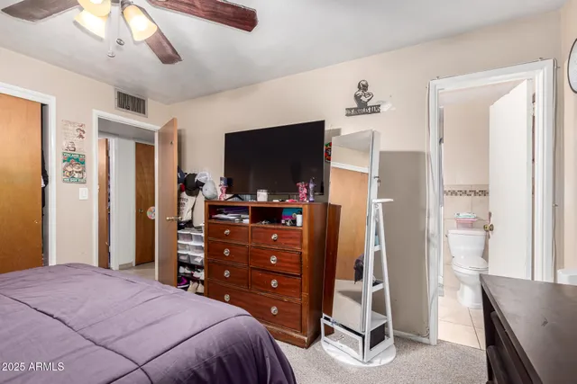 a bedroom with a bed and a flat screen tv