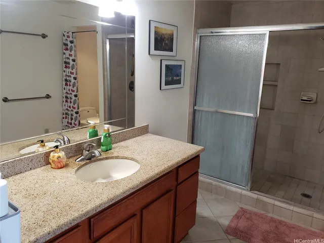 a bathroom with a granite countertop sink a mirror and shower