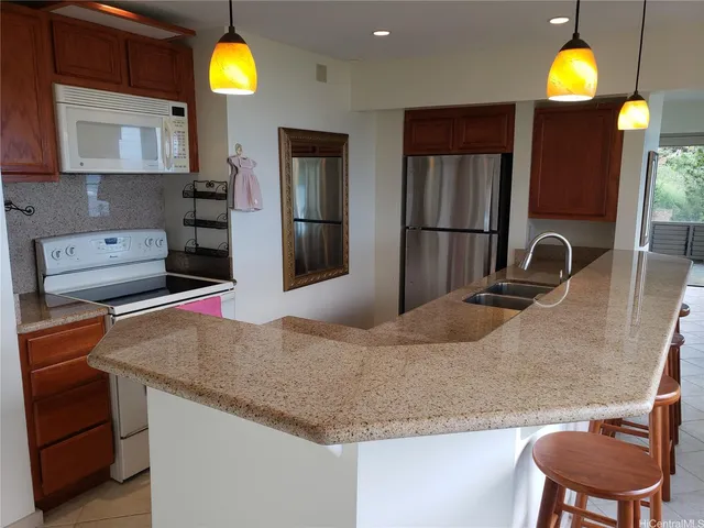 a kitchen with kitchen island a sink stainless steel appliances and a counter top space