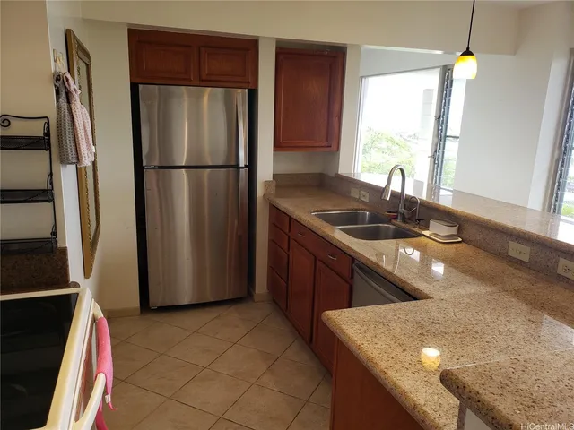 a kitchen with stainless steel appliances granite countertop a sink a refrigerator and a granite counter tops