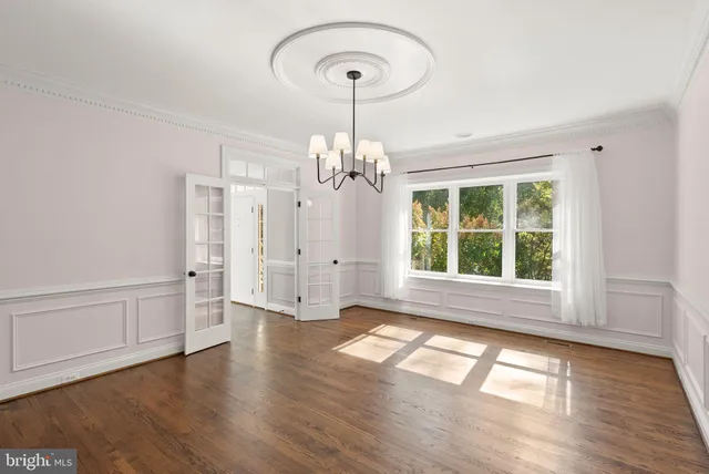 an empty room with windows and ceiling fan