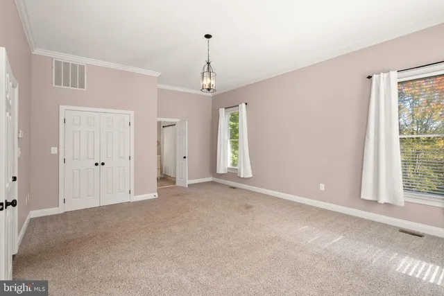 a view of a hallway with wooden floor and closet