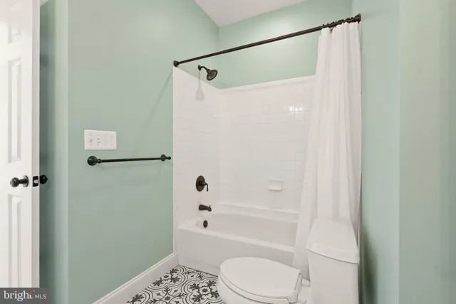 a view of a white house with a big yard and potted plants