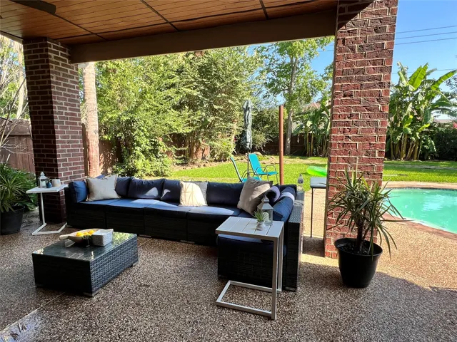 a living room with patio furniture and a potted plant