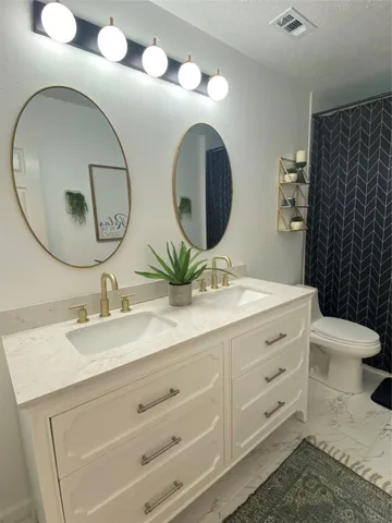 a bathroom with a double vanity sink and a mirror