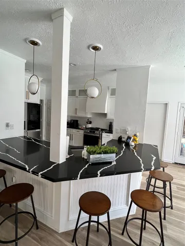a kitchen with a dining table chairs and a chandelier