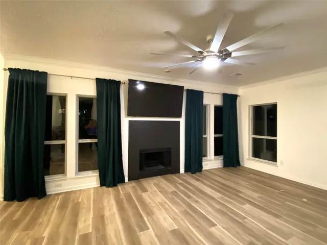 a view of a livingroom with wooden floor and a ceiling fan