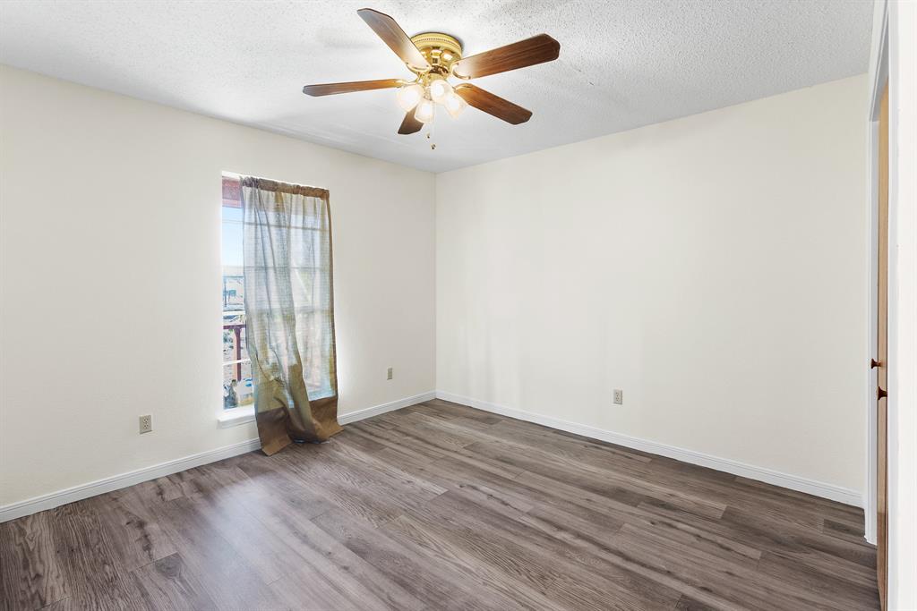 8548 Old Lockhart Road Buda, TX 78610 - Photo 13 of 19 an empty room with wooden floor and windows