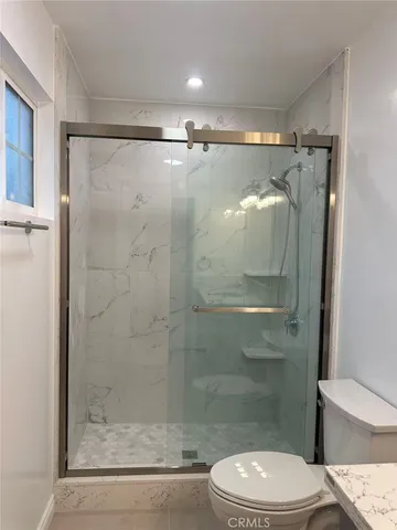 a white toilet sitting next to a shower