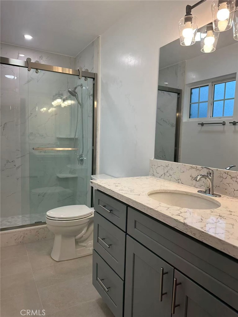 3044 Hodges Avenue Arcadia, CA 91006 - Photo 10 of 13 a bathroom with a granite countertop sink a toilet a mirror and shower