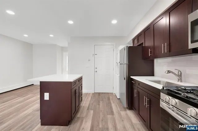 a kitchen with stainless steel appliances granite countertop a stove and a refrigerator