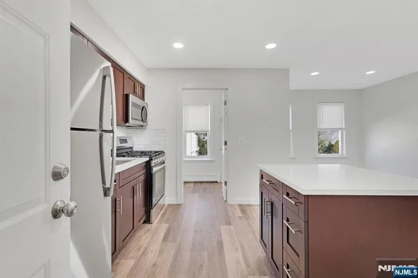a kitchen with granite countertop a sink stove and refrigerator