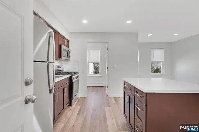 a kitchen with granite countertop a sink stove and refrigerator