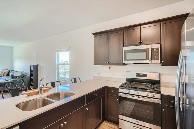 a kitchen with appliances a sink cabinets and a window