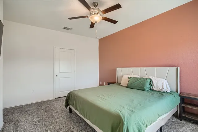 a bedroom with a bed and a ceiling fan
