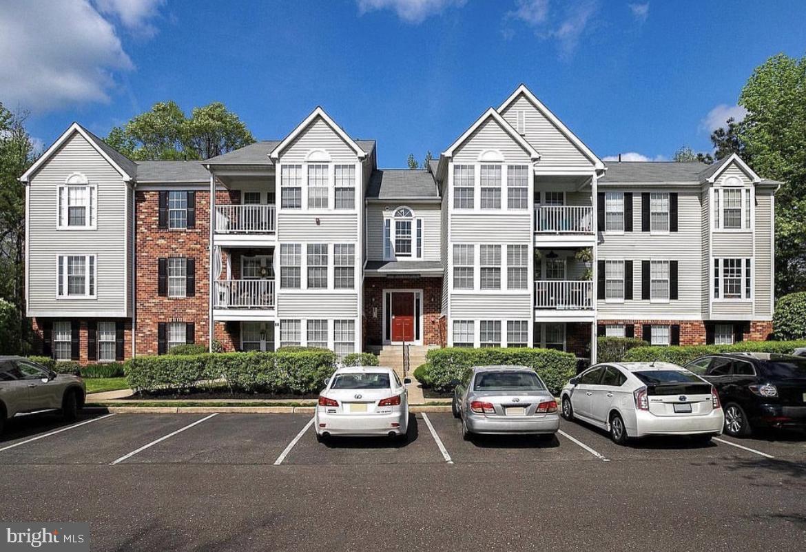 a view of a city street with a couple of cars parked in front of a house