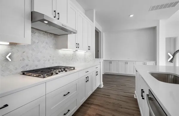 a view of kitchen with stainless steel appliances cabinets and wooden floor