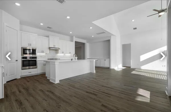 a kitchen with white cabinets stove and sink