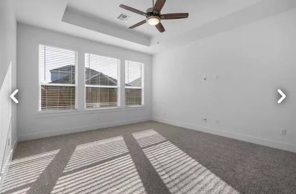 a view of a kitchen and an empty room with wooden floor and a window