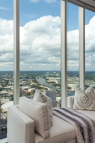 a living room with couches chairs and city view