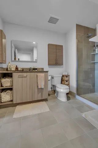 a bathroom with a granite countertop sink a toilet and shower