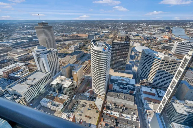 a living room with furniture a chandelier and kitchen view