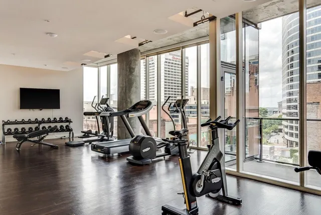 a living room with furniture a large window and wooden floor