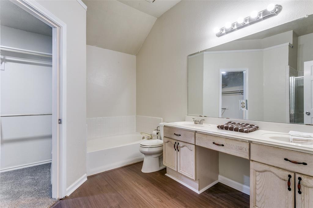 2133 Rim Rock Drive Keller, TX 76248 - Photo 26 of 37 Bathroom featuring double vanity, a bath, a shower stall, dark wood finished floors, and a closet