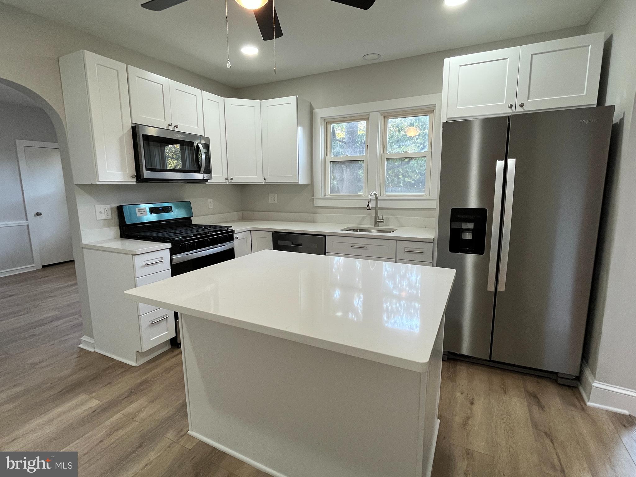 105 Mecray Lane Maple Shade, NJ 08052 - Photo 8 of 32 a white refrigerator freezer sitting inside of a kitchen with stainless steel appliances wooden floor