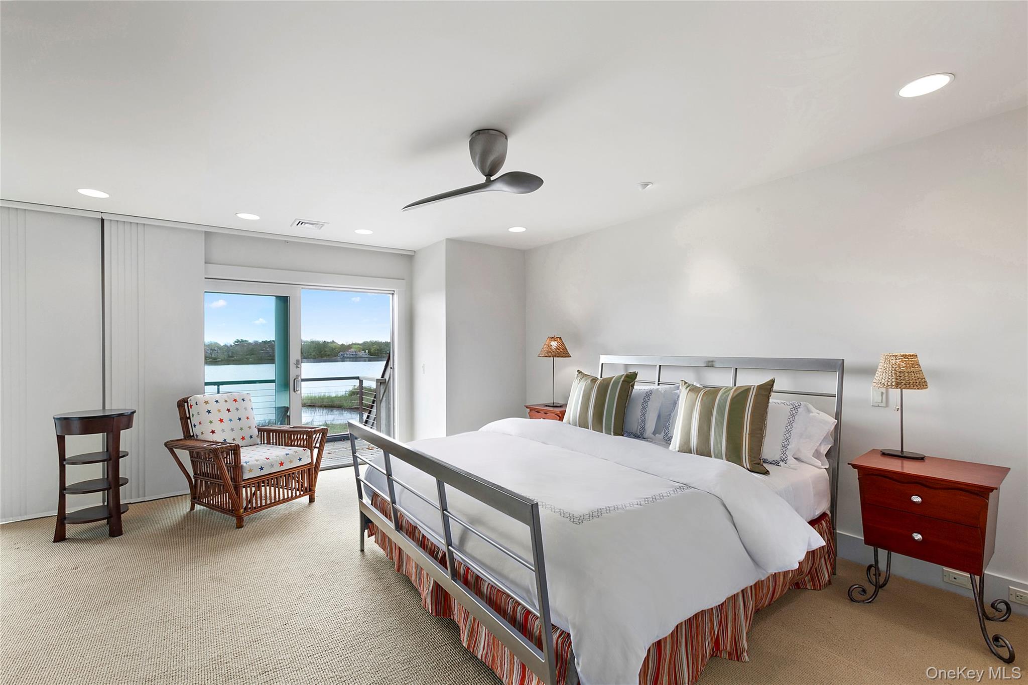 316 Deerfield Road Water Mill, NY 11976 - Photo 17 of 22 a spacious bedroom with a bed and a chandelier