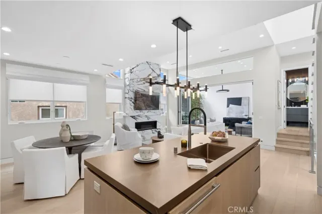 a kitchen with stainless steel appliances granite countertop a sink dishwasher and a refrigerator with wooden floor