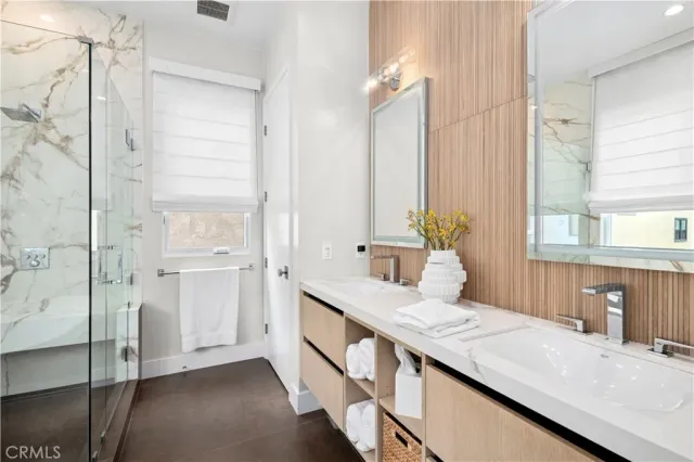 a bathroom with a sink and mirror with bathtub