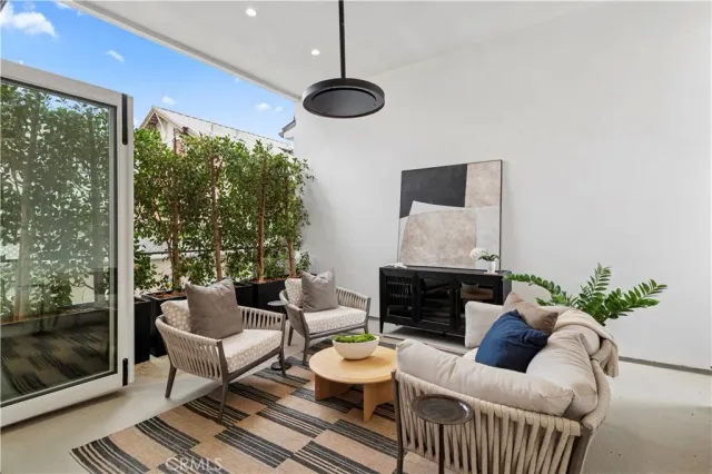a living room with furniture a chandelier and a flat screen tv