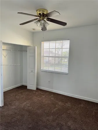 an empty room with chandelier fan