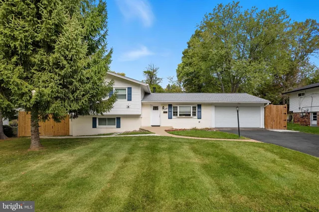 a front view of a house with a yard and trees