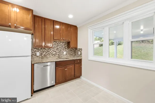 a kitchen with stainless steel appliances granite countertop a refrigerator and a sink